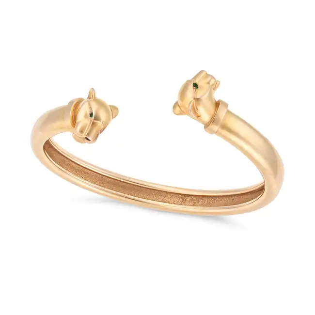 A TSAVORITE GARNET AND ONYX PANTHER BANGLE the open cuff bangle terminating at each end with a