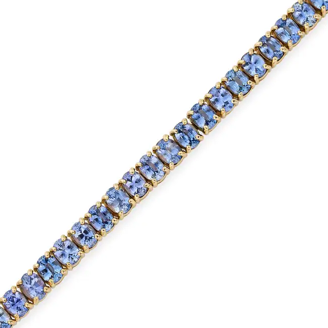 A SAPPHIRE LINE BRACELET in 18ct yellow gold, comprising a row of oval cut sapphires totalling 6.7-