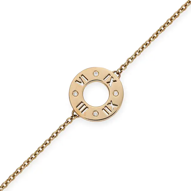 TIFFANY & CO., A DIAMOND ATLAS BRACELET comprising circular disc with cut out Roman numerals,