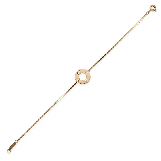 TIFFANY & CO., A DIAMOND ATLAS BRACELET comprising circular disc with cut out Roman numerals,