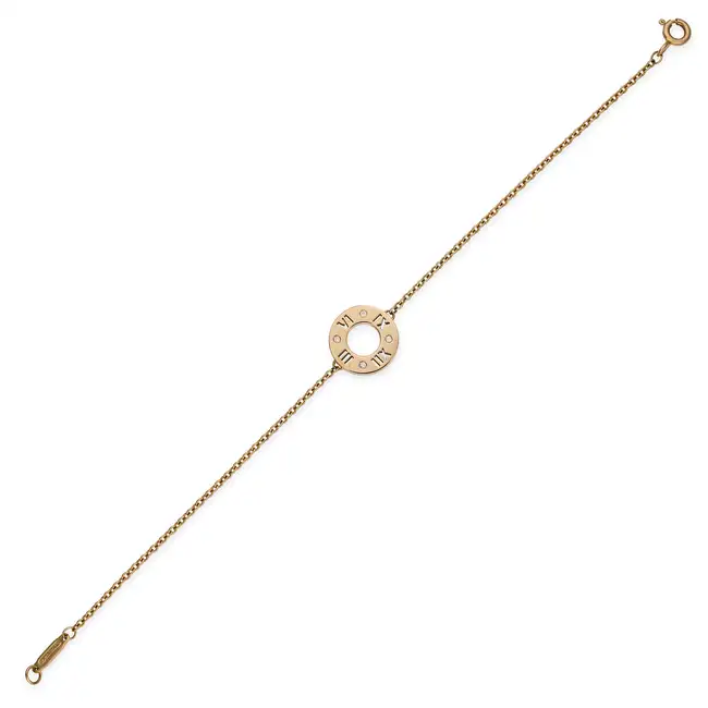 TIFFANY & CO., A DIAMOND ATLAS BRACELET comprising circular disc with cut out Roman numerals,
