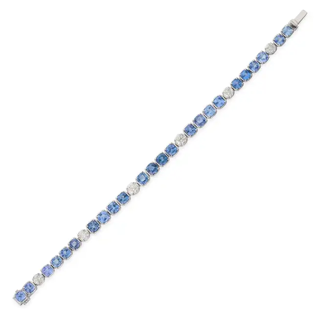 OSCAR FRIEDMAN, A SAPPHIRE AND DIAMOND LINE BRACELET set with a row of cushion cut sapphires,