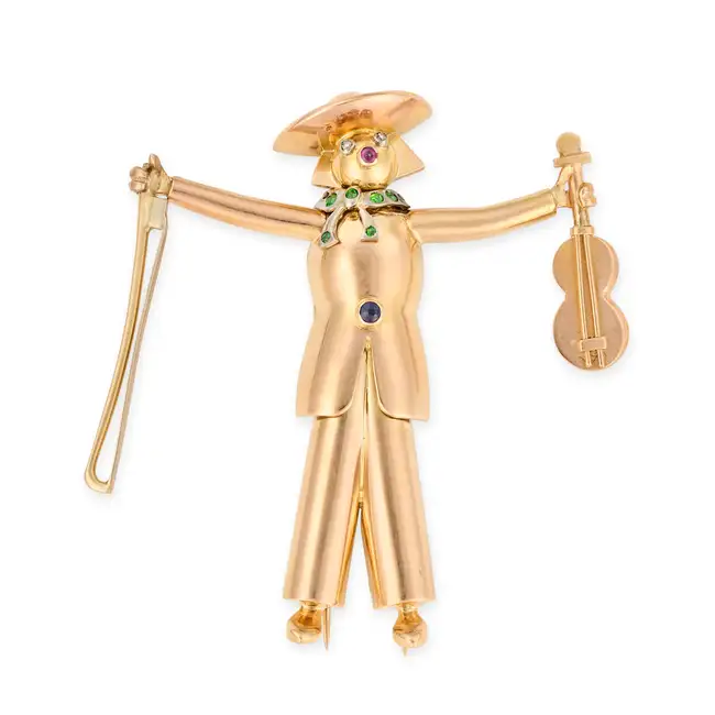 A VINTAGE NOVELTY GEMSET AND DIAMOND VIOLINIST BROOCH in yellow gold, designed to depict a