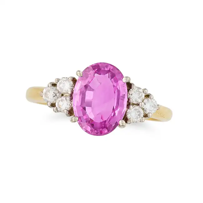 A PINK SAPPHIRE AND DIAMOND DRESS RING in 18ct yellow gold, set with an oval cut pink sapphire of
