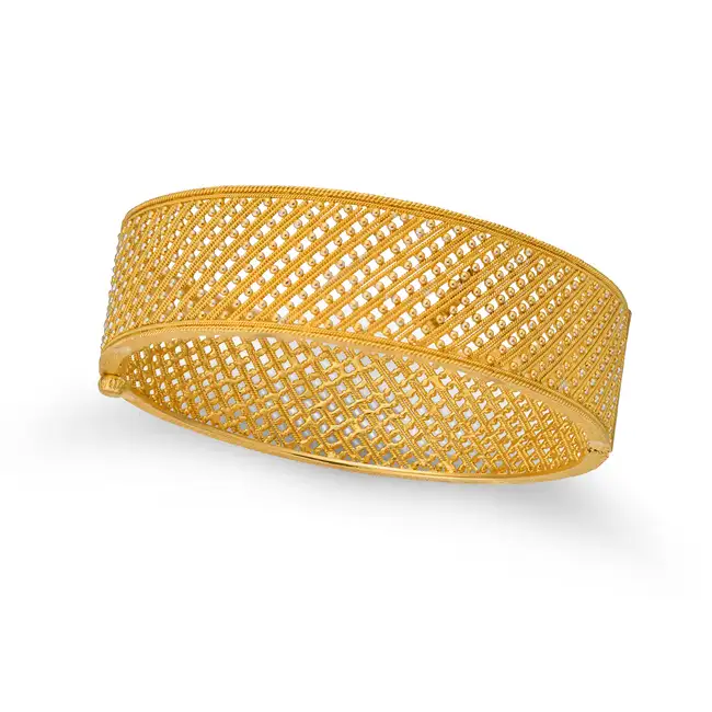 A GOLD BANGLE in yellow gold, the hinged openwork bangle designed as rows of twisted wirework,