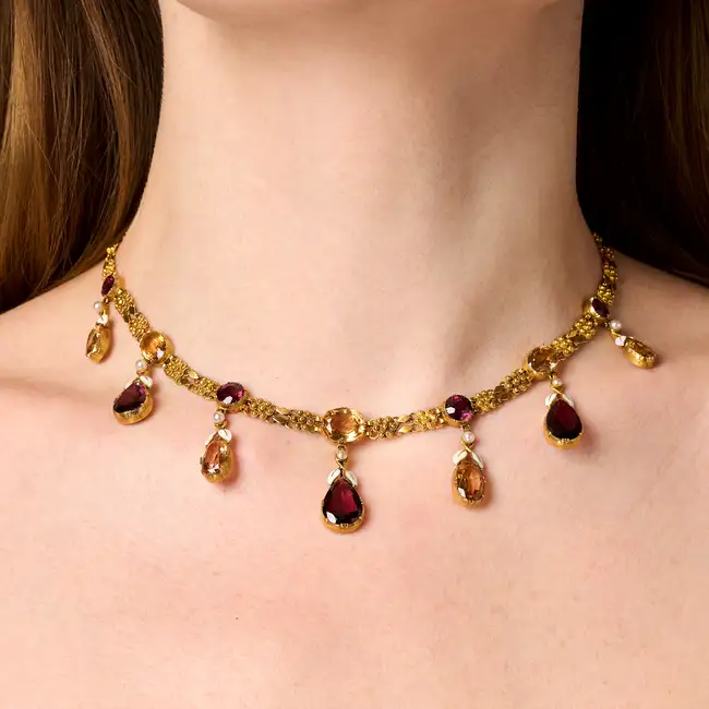 ALFRED PHILIPS, A FINE ANTIQUE IMPERIAL TOPAZ AND GARNET NECKLACE in yellow gold, comprising a row