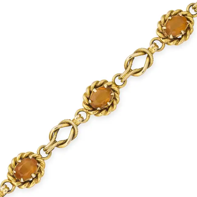 A VINTAGE CITRINE BRACELET in 9ct yellow gold, comprising six oval cut citrines within twisted