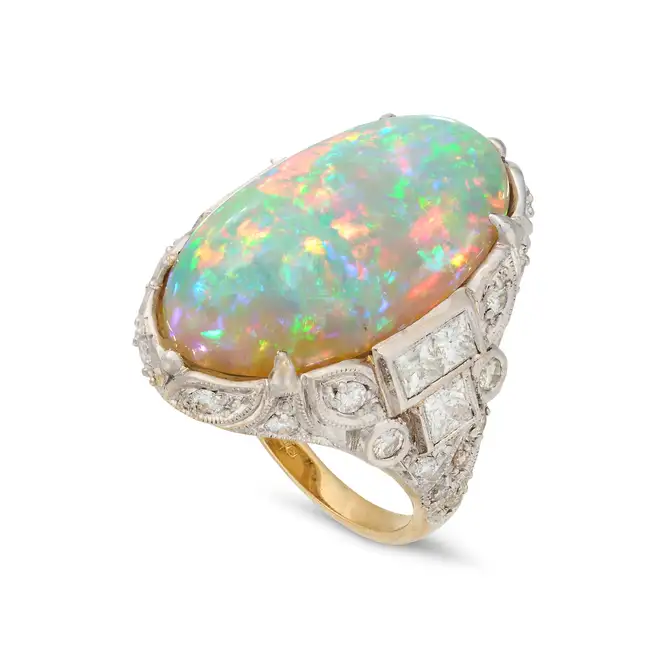 A VINTAGE OPAL AND DIAMOND DRESS RING set with an oval cabochon opal of approximately 11.34
