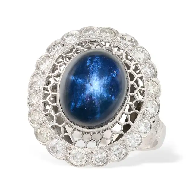A STAR SAPPHIRE AND DIAMOND DRESS RING the openwork ring set with an oval cabochon star sapphire