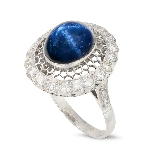 A STAR SAPPHIRE AND DIAMOND DRESS RING the openwork ring set with an oval cabochon star sapphire