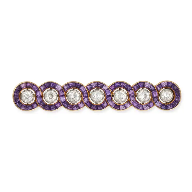 CARTIER, AN ART DECO AMETHYST AND DIAMOND BAR BROOCH in 18ct yellow gold, set with a row of seven