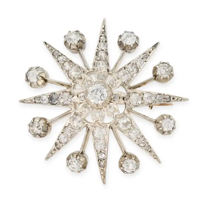 AN ANTIQUE DIAMOND STAR BROOCH designed as an eight rayed star with a flower motif in the centre,