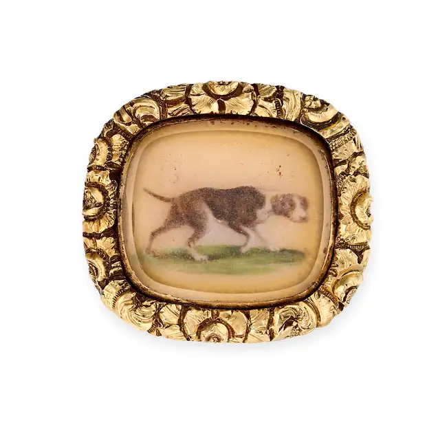 AN ANTIQUE GEORGIAN DOG MINIATURE BROOCH comprising a painted miniature of a dog over a ground of