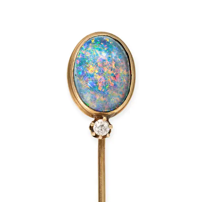 AN ANTIQUE BLACK OPAL AND DIAMOND STICK / TIE PIN BROOCH in yellow gold, set with an oval cabochon
