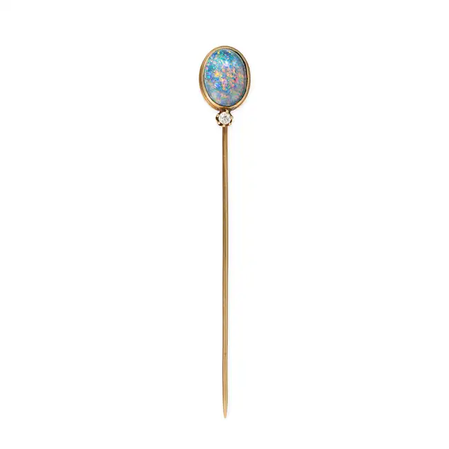 AN ANTIQUE BLACK OPAL AND DIAMOND STICK / TIE PIN BROOCH in yellow gold, set with an oval cabochon