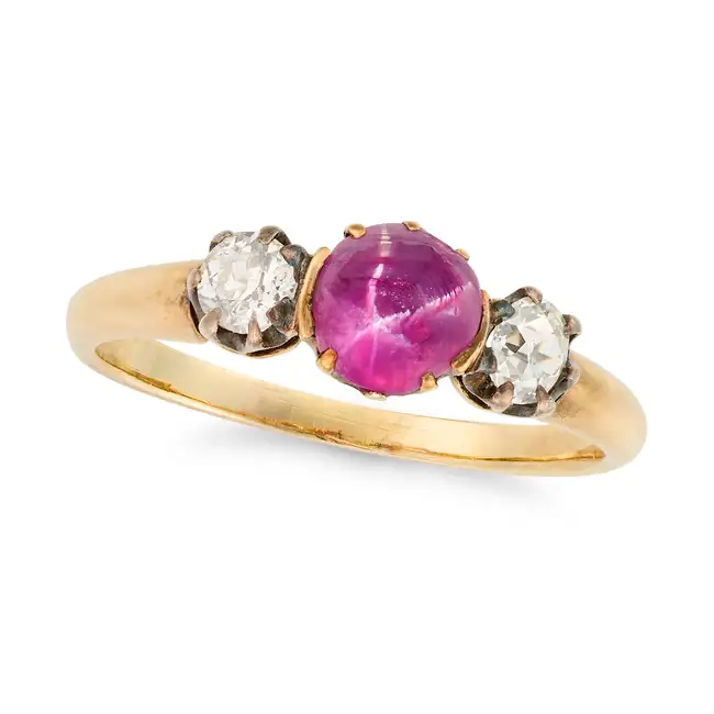 AN ANTIQUE STAR RUBY AND DIAMOND THREE STONE RING in yellow gold, set with a cabochon star ruby