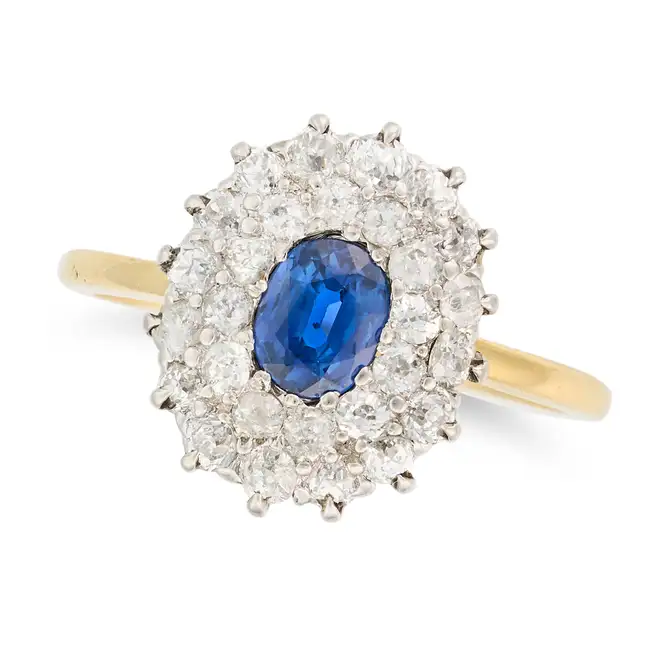 A SAPPHIRE AND DIAMOND CLUSTER RING set with an oval cut sapphire within a cluster of old cut