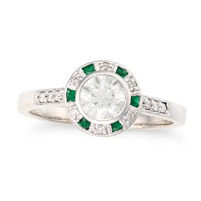 A DIAMOND AND EMERALD TARGET RING set with an old cut diamond of approximately 0.70 carats in a