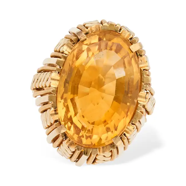 A VINTAGE CITRINE RING in 18ct yellow gold, set with an oval cut citrine, the stylised gallery