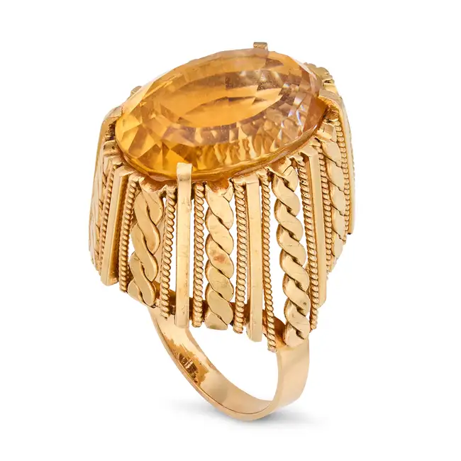 A VINTAGE CITRINE RING in 18ct yellow gold, set with an oval cut citrine, the stylised gallery