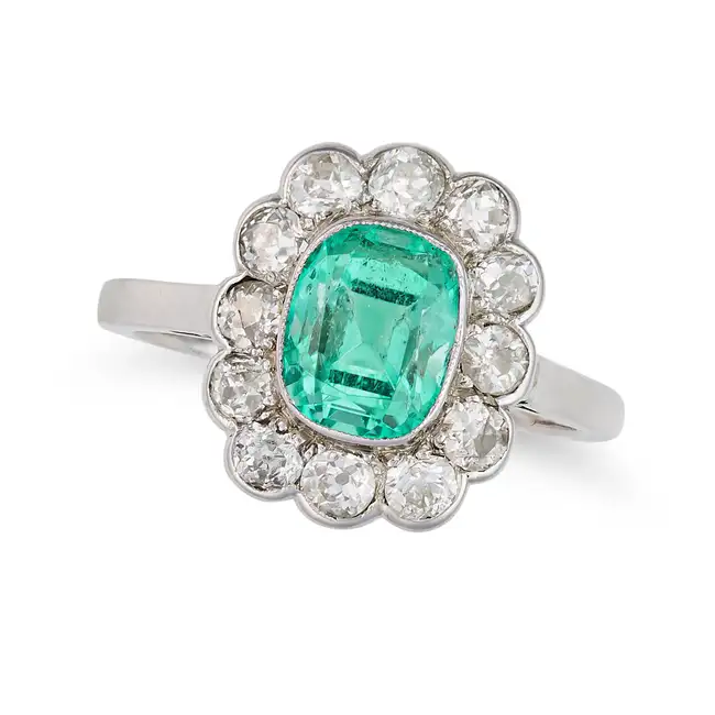 AN EMERALD AND DIAMOND CLUSTER RING set with a cushion cut emerald of approximately 1.49 carats in a