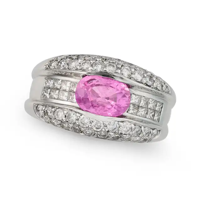 A PINK SAPPHIRE AND DIAMOND DRESS RING in 14ct white gold, set with an oval cut pink sapphire of