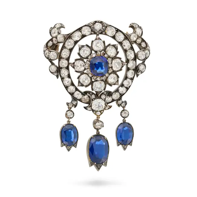 A FINE ANTIQUE SAPPHIRE AND DIAMOND BROOCH in yellow gold and silver, designed as a flower set