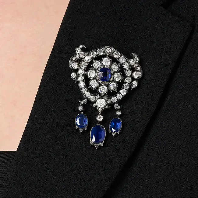 A FINE ANTIQUE SAPPHIRE AND DIAMOND BROOCH in yellow gold and silver, designed as a flower set