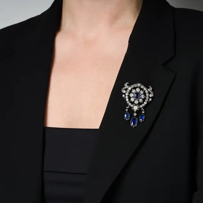 A FINE ANTIQUE SAPPHIRE AND DIAMOND BROOCH in yellow gold and silver, designed as a flower set