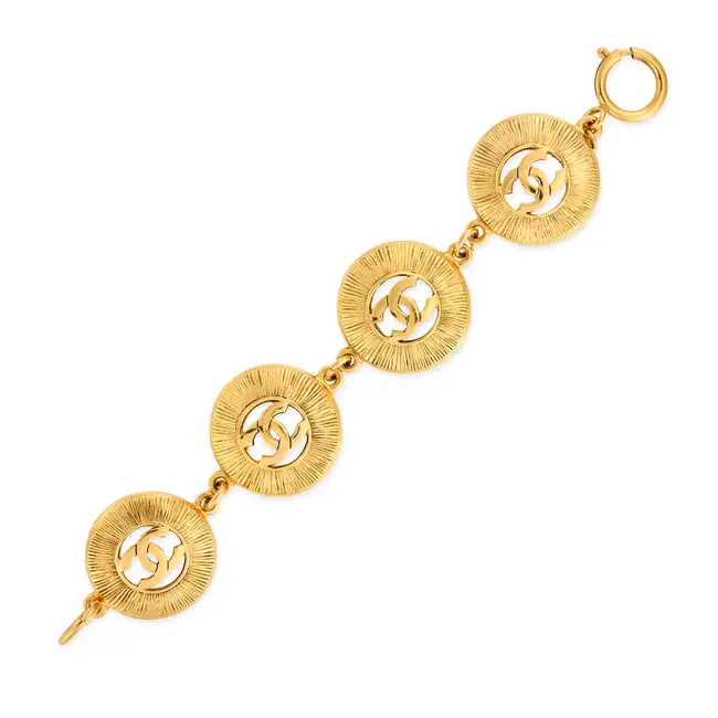 CHANEL, A SUNBURST BRACELET comprising four textured circular gold tone metal links with an