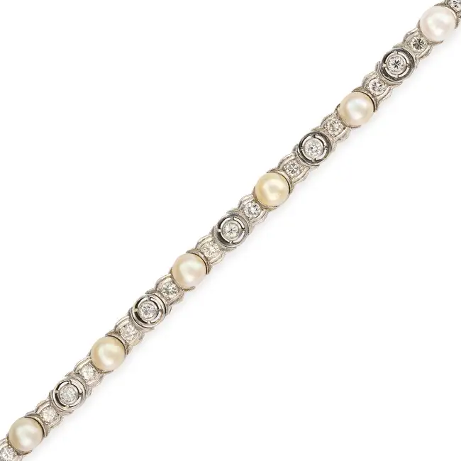 A VINTAGE PEARL AND DIAMOND BRACELET in platinum and white gold, comprising a row of round brilliant