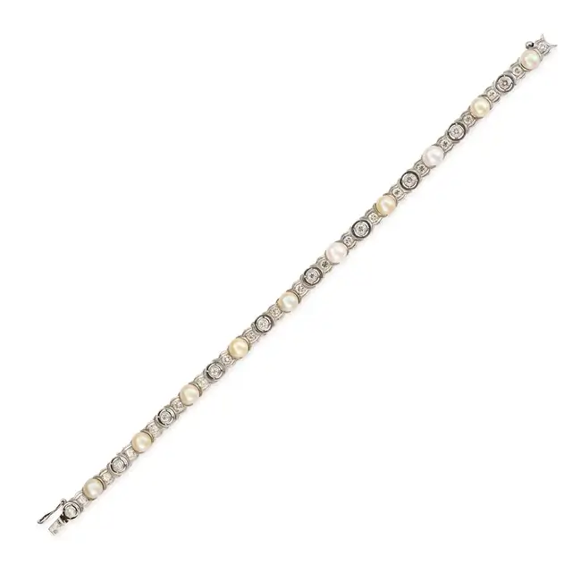 A VINTAGE PEARL AND DIAMOND BRACELET in platinum and white gold, comprising a row of round brilliant