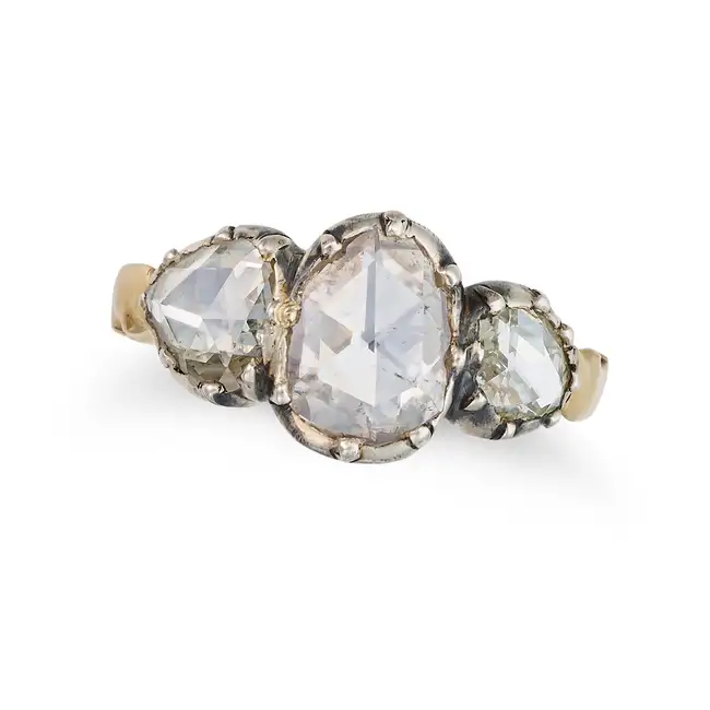 AN ANTIQUE DIAMOND THREE STONE RING in yellow gold and silver, set with three rose cut diamonds,