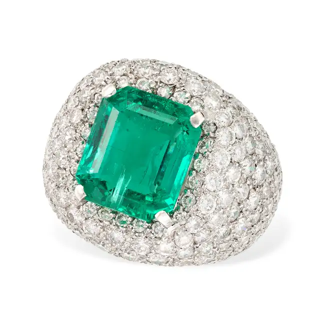A FINE COLOMBIAN MINOR EMERALD AND DIAMOND DRESS RING set with an octagonal step cut emerald of 7.95
