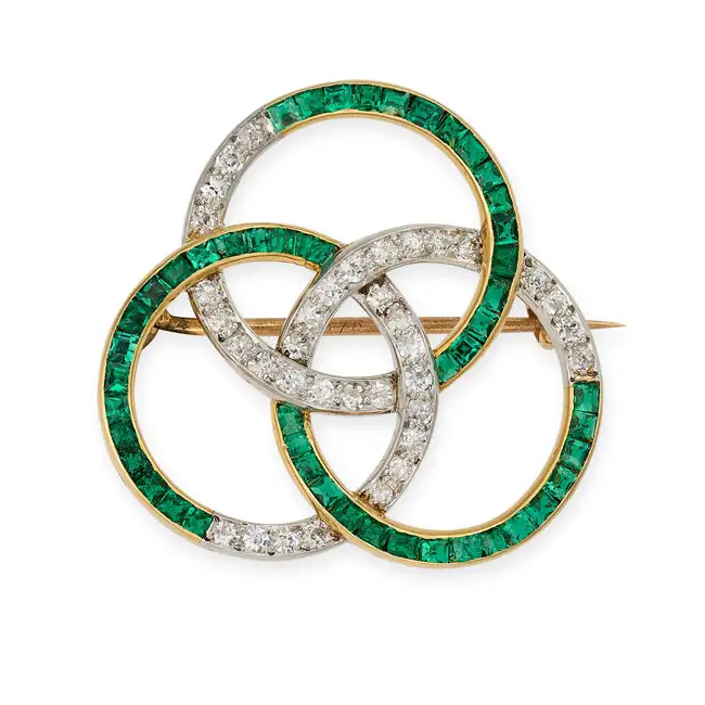 AN ANTIQUE EMERALD AND DIAMOND BROOCH, EARLY 20TH CENTURY designed as three interlocking circles set