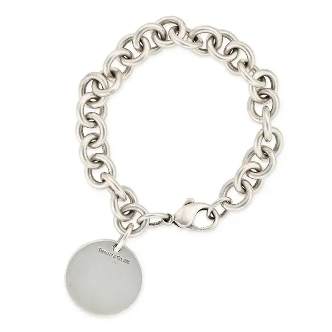 TIFFANY & CO., A SILVER CHARM / TAG BRACELET the circular link bracelet suspending a circular tag