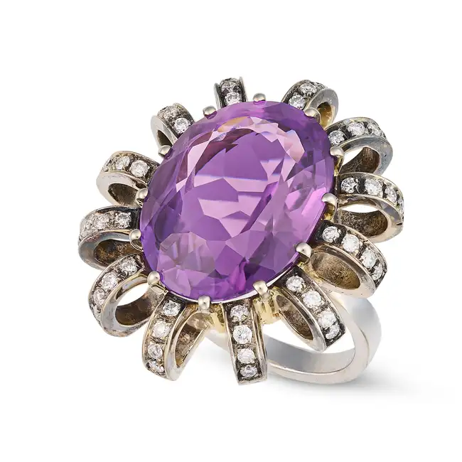 AN AMETHYST AND DIAMOND DRESS RING set with an oval cut amethyst of approximately 12.85 carats,