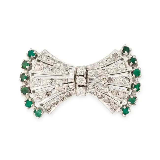 NO RESERVE - A VINTAGE DIAMOND AND EMERALD BOW BROOCH designed as a bow set with round brilliant and