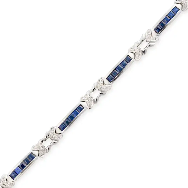 A SAPPHIRE AND DIAMOND BRACELET comprising links set with square step cut sapphires, accented by