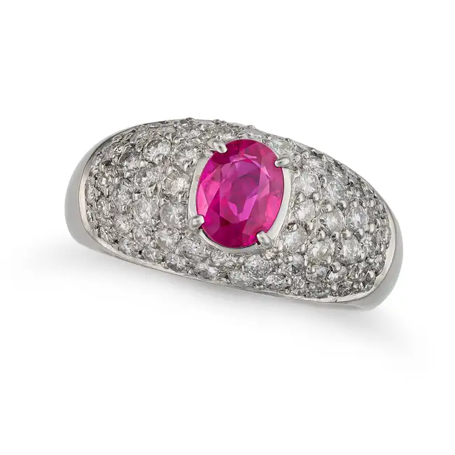 A RUBY AND DIAMOND DRESS RING set with an oval cut ruby of 1.41 carats, accented by pave set round