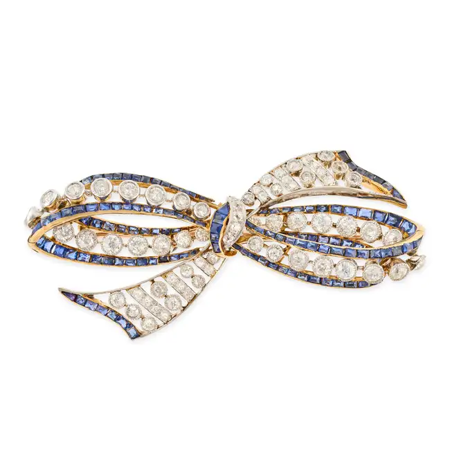 AN ANTIQUE DIAMOND AND SAPPHIRE BOW BROOCH, EARLY 20TH CENTURY designed as an openwork bow set