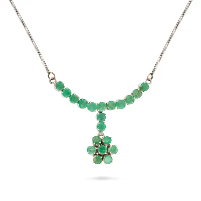 AN EMERALD PENDANT NECKLACE comprising a curb chain set with a row of round cut emeralds, suspending