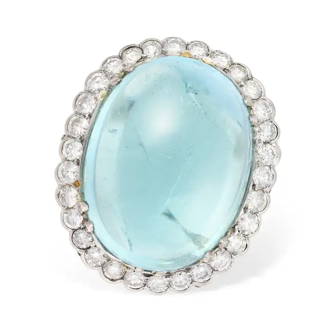 A LARGE AQUAMARINE AND DIAMOND DRESS RING set with an oval cabochon aquamarine of approximately 29.