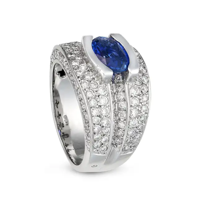 A SAPPHIRE AND DIAMOND DRESS RING set with an oval cut sapphire of approximately 2.57 carats,