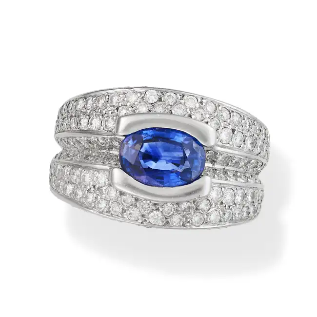 A SAPPHIRE AND DIAMOND DRESS RING set with an oval cut sapphire of approximately 2.57 carats,