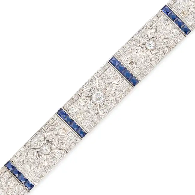 AN ART DECO SAPPHIRE AND DIAMOND STRAP BRACELET comprising a row of pierced geometric links set with