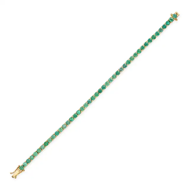 A 6.98 CARAT EMERALD LINE BRACELET comprising a row of round cut emerald totalling 6.98 carats,