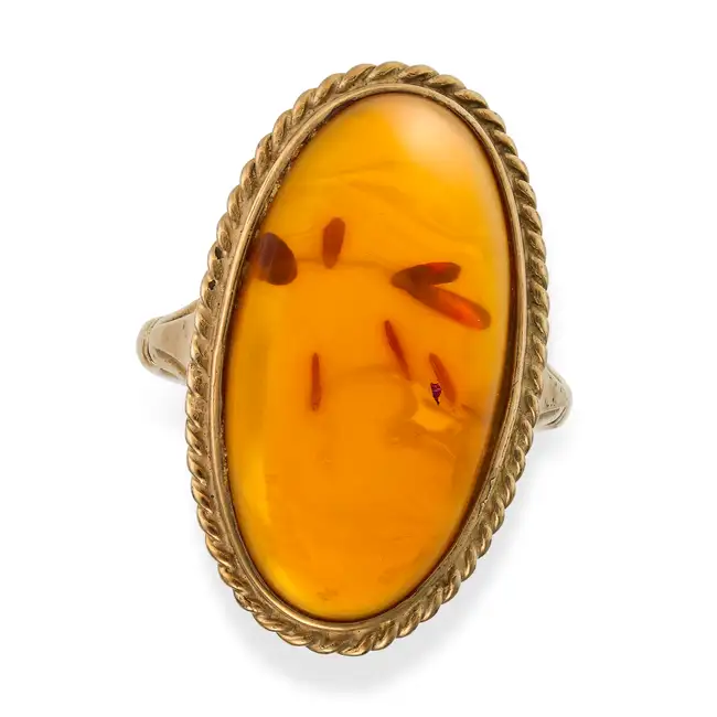 NO RESERVE - A VINTAGE AMBER RING in 9ct yellow gold, set with an oval cabochon amber within a