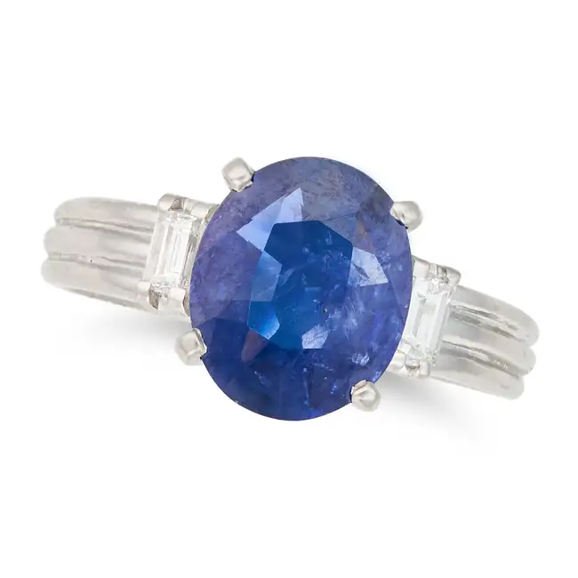 A SAPPHIRE AND DIAMOND THREE STONE RING set with an oval cut sapphire of approximately 2.06