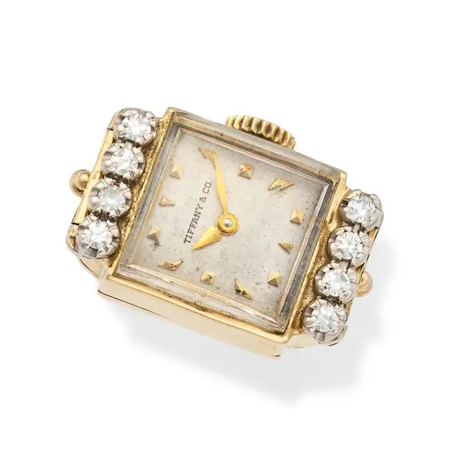 A DIAMOND WATCH RING the rectangular dial signed Tiffany & Co. with baton hour markers, set to the